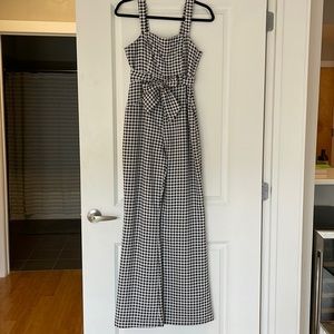 Gingham jumpsuit with bow waist detail and slightly flared pants.